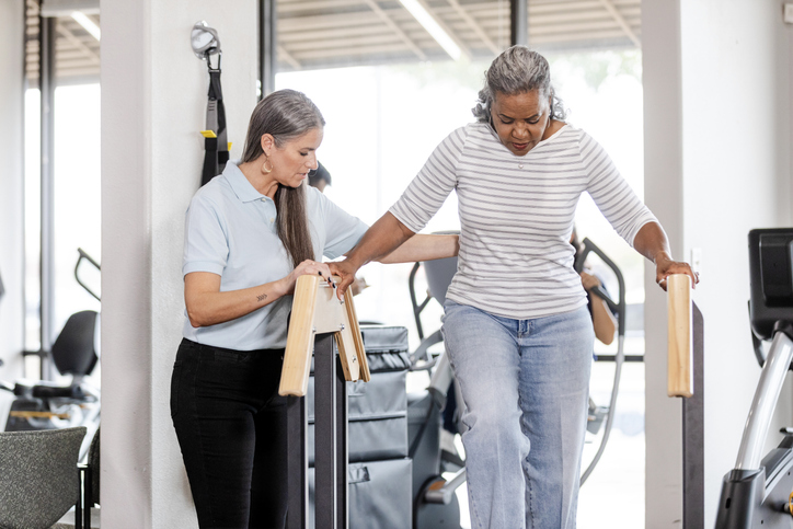 Senior female patient carefully walks down stairs at the occupational therapy clinic in Spring Lake