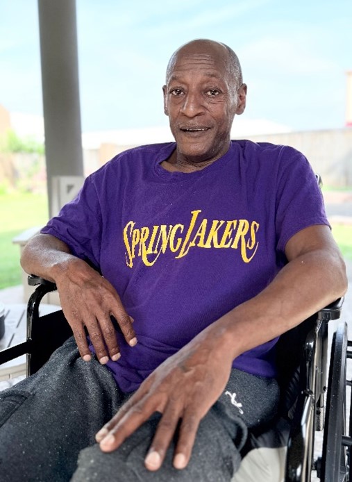 A gentleman in Spring Lakers shirt and wheelchair enjoys the sunshine in Shreveport