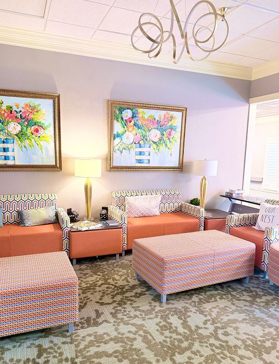 Lobby featuring vibrant orange couches and chairs, showcasing community amenities in Spring Lake, LA