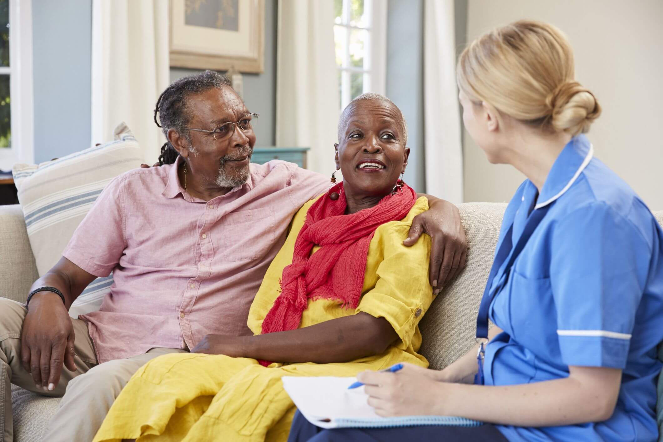 Skilled Nursing & Rehabilitation nurse speaks with elderly man and woman on a couch in Spring Lake
