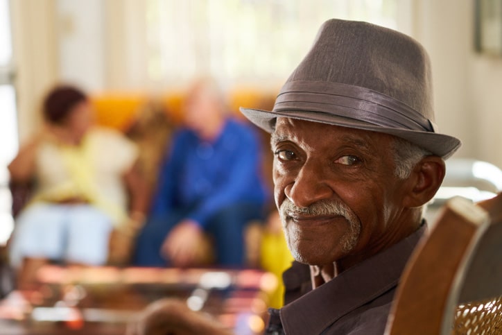 Senior man in a grey hat sitting in the lobby