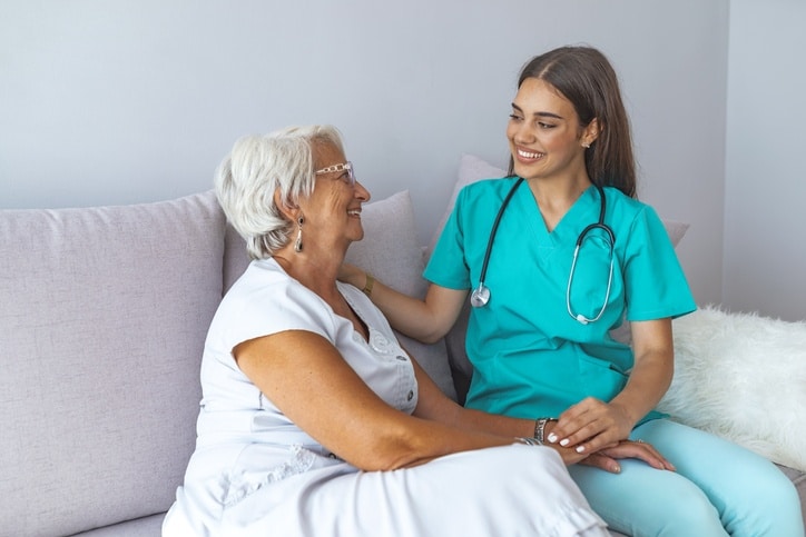 Senior woman in respite care comforted by a nurse