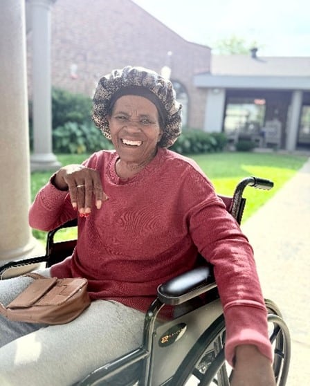 Smiling woman in a wheelchair enjoying the sunshine